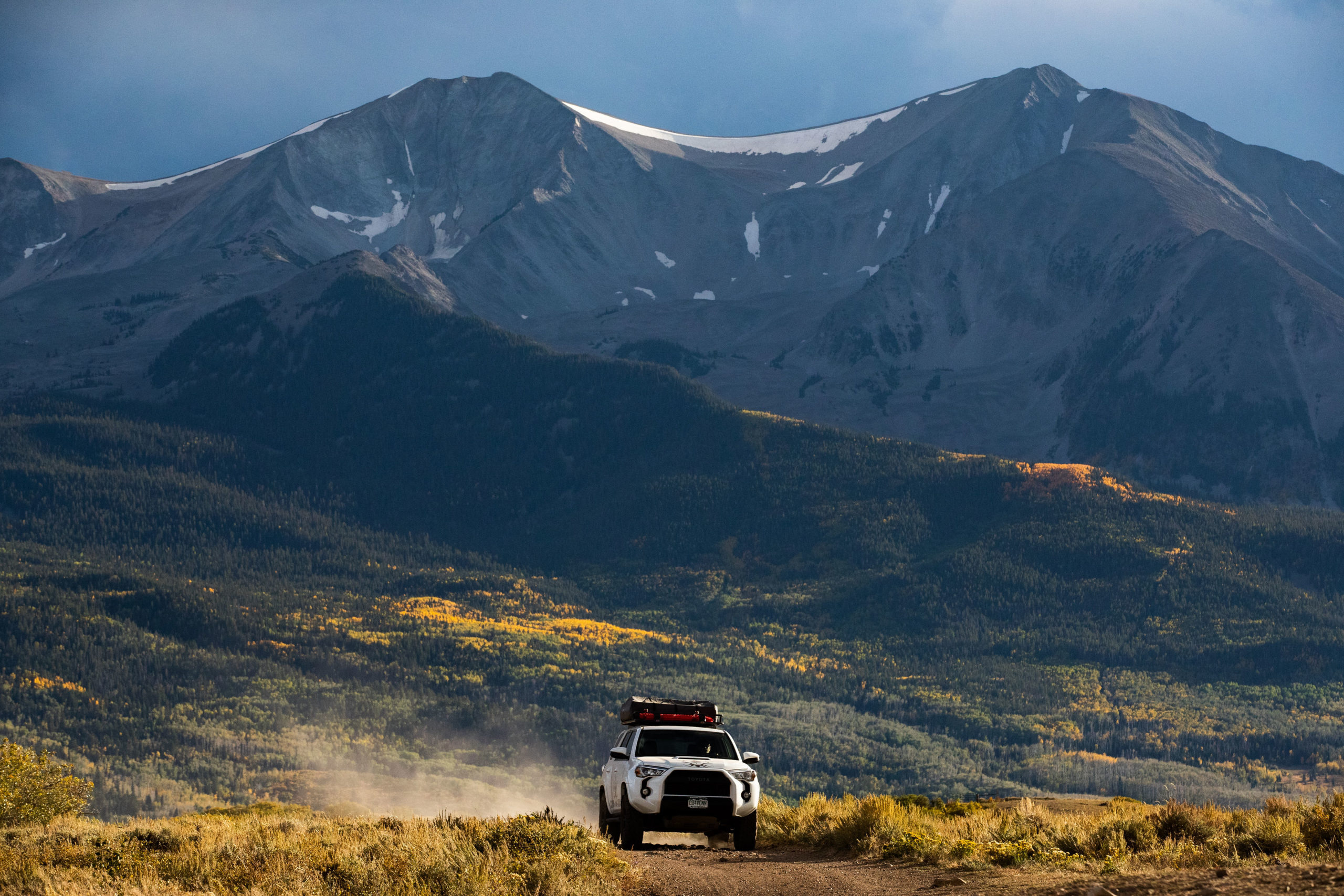 Image of a Colorado Overlander Toyota 4Runner TRD Pro driving on a dirt road. There is an epic mountain view in the background.